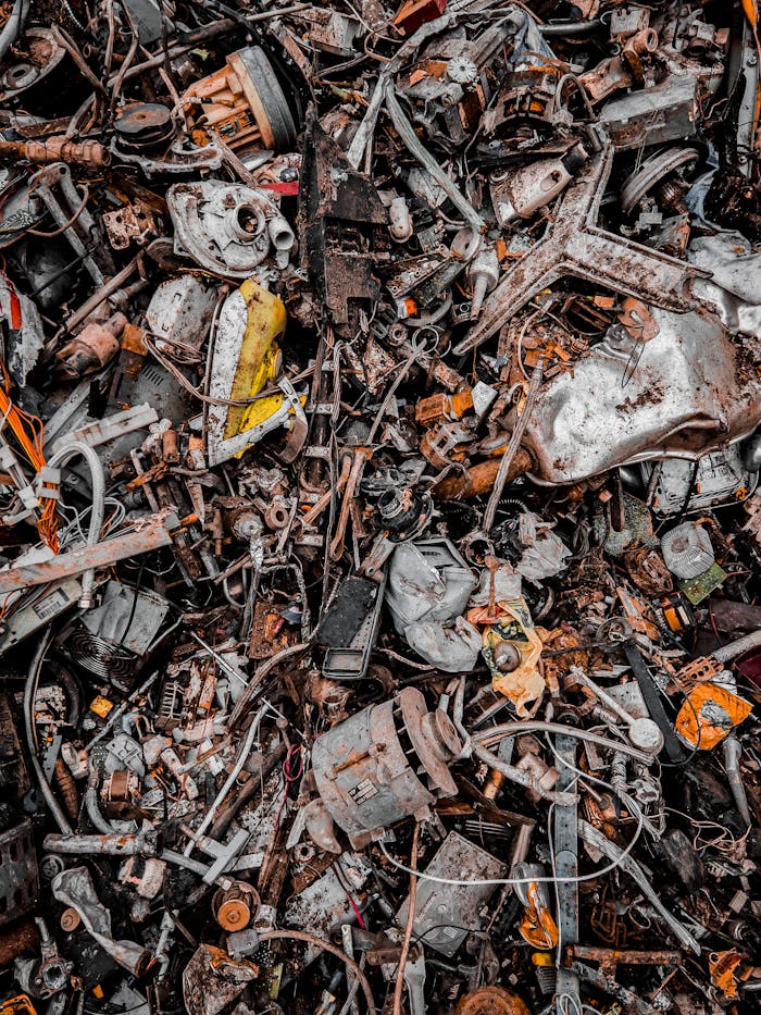 A chaotic pile of metal scrap and waste, showcasing decaying and rusty components in an industrial setting.